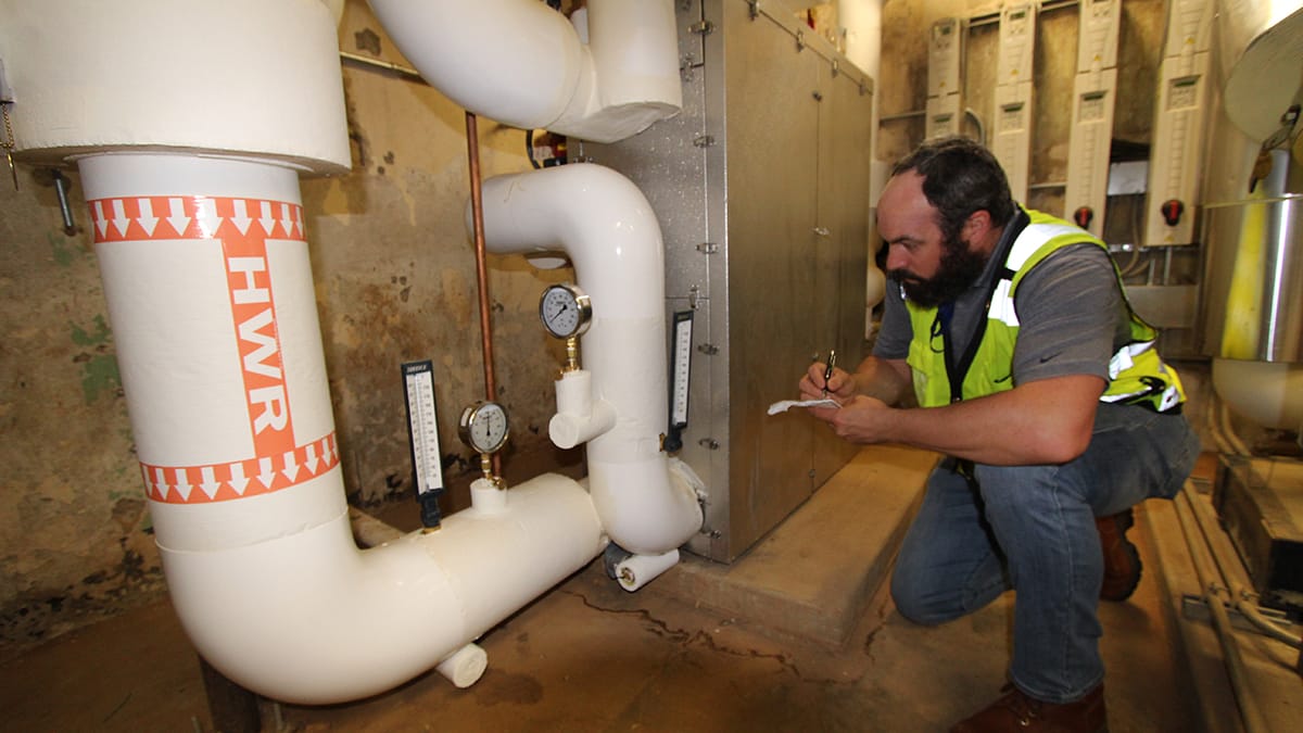 RMF Engineer inspecting steam to hot water conversion - Image 1